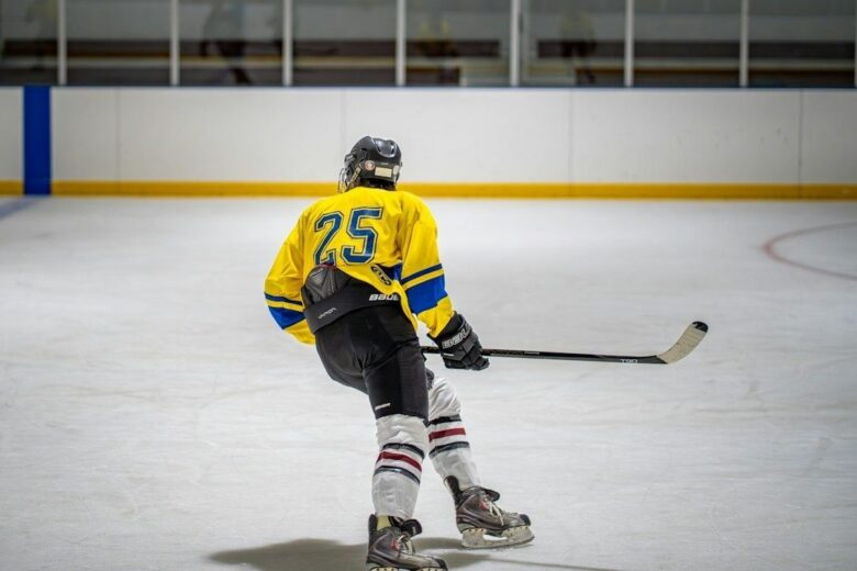 IJshockeyspeler in bocht op het ijs met gebogen schaatsijzer