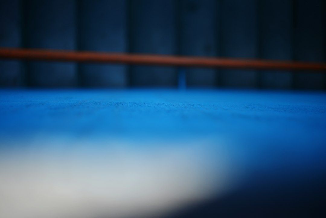 Abstracte blauwe close-up van een glad ijsoppervlak met een rood lint